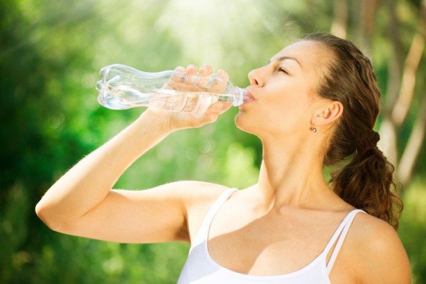 Девушка пьет воду для похудения